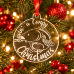 A Carpy Christmas acrylic fishing bauble displayed on a festive Christmas tree
